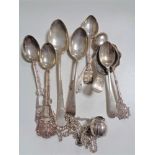 A collection of silver and white metal spoons,