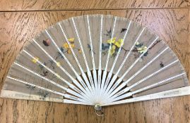 A nineteenth century ivory hand fan with painted lace decoration depicting butterflies