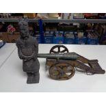 An ornamental decorative canon and a Chinese style pottery figure.