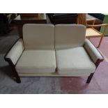 A contemporary two seater settee in oatmeal fabric