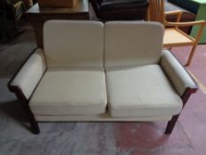 A contemporary two seater settee in oatmeal fabric