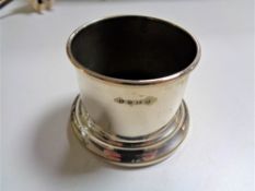 A small silver cup, 78.8g, together with a plated bottle stand.