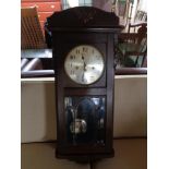 An Edwardian oak cased wall clock