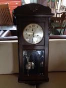 An Edwardian oak cased wall clock