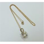 A 10ct gold diamond and pearl pendant on yellow gold chain