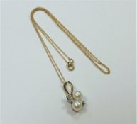 A 10ct gold diamond and pearl pendant on yellow gold chain