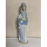 A Lladro figure of a girl holding flowers