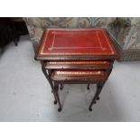 A nest of three mahogany leather topped tables