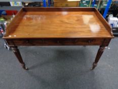 A William IV mahogany library/writing table fitted with three drawers on turned legs raised on