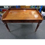 A William IV mahogany library/writing table fitted with three drawers on turned legs raised on