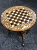 A circular inlaid hardwood occasional table on elephant leg supports CONDITION REPORT:
