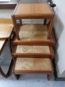 A nest of three twentieth century tiled tables and lamp table