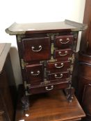 A miniature oriental style seven drawer chest with brass mounts