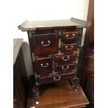 A miniature oriental style seven drawer chest with brass mounts