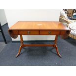 A yewwood flap sided sofa table fitted with two drawers