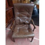 A mid century brown leather armchair