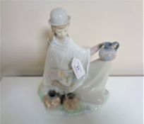 A large Lladro figure, lady holding a child.