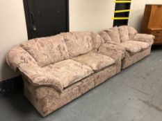 A three seater and two seater settee upholstered in geometric and floral fabric