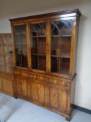 A mahogany Regency style triple door bookcase with lion mask handles, height 199.