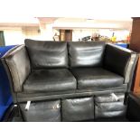 A Danish black leather two seater settee