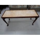 A mahogany coffee table with marble inset panel