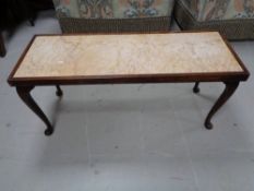 A mahogany coffee table with marble inset panel