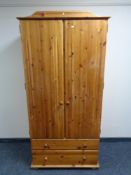 A pine double door wardrobe fitted with two drawers