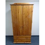 A pine double door wardrobe fitted with two drawers