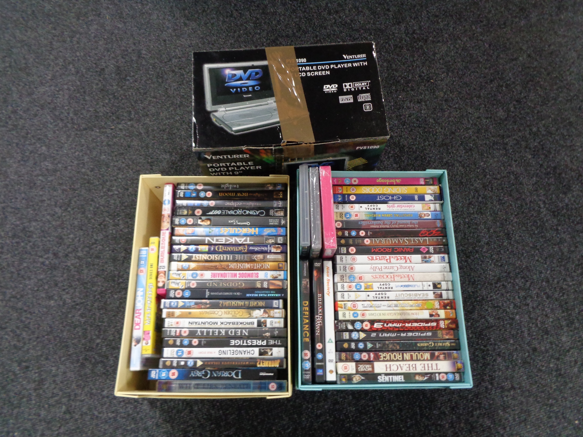 Two boxes of DVDs and a portable DVD player.