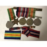 A group of three WWII medals on bar together with two further medals of the same war.