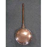 An antique copper bed warming pan