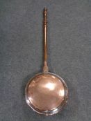 An antique copper bed warming pan