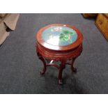 A Chinese hardwood circular plant table with inset cloisonne top