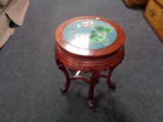 A Chinese hardwood circular plant table with inset cloisonne top