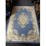 A floral woolen rug on blue ground,