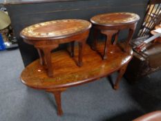 An oval eastern style coffee table with brass inlay together with pair of matching side tables