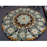 A circular chain stitched rug flowers on brown ground