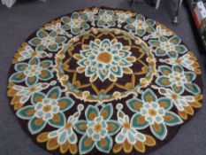 A circular chain stitched rug flowers on brown ground