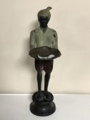 A bronze patinated figure depicting a servant holding a tray