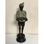 A bronze patinated figure depicting a servant holding a tray