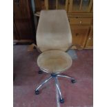 A tan leather swivel chair on chrome base