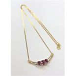 An 18ct yellow gold ruby and diamond pendant on chain,