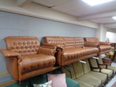 A mid century Danish brown leather three piece lounge suite comprising three seater settee,