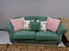 A twentieth century continental two seater settee in green fabric with scatter cushions