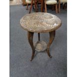 An early twentieth century carved circular two tier table