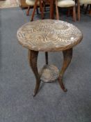 An early twentieth century carved circular two tier table