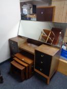 A mid century teak knee hole dressing table with headboard together with a further nest of teak