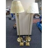 A pair of brass finished floor lamps together with a pair of brass table lamps