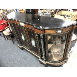 A Victorian ebonised four door break-fronted credenza with brass mounts and hand painted porcelain