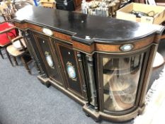 A Victorian ebonised four door break-fronted credenza with brass mounts and hand painted porcelain